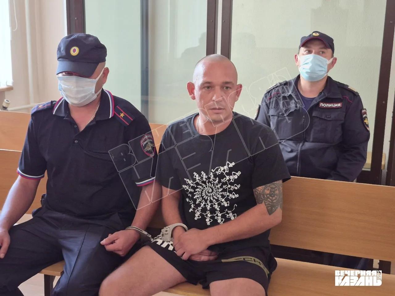задержанный сидит в зале суда под конвоем